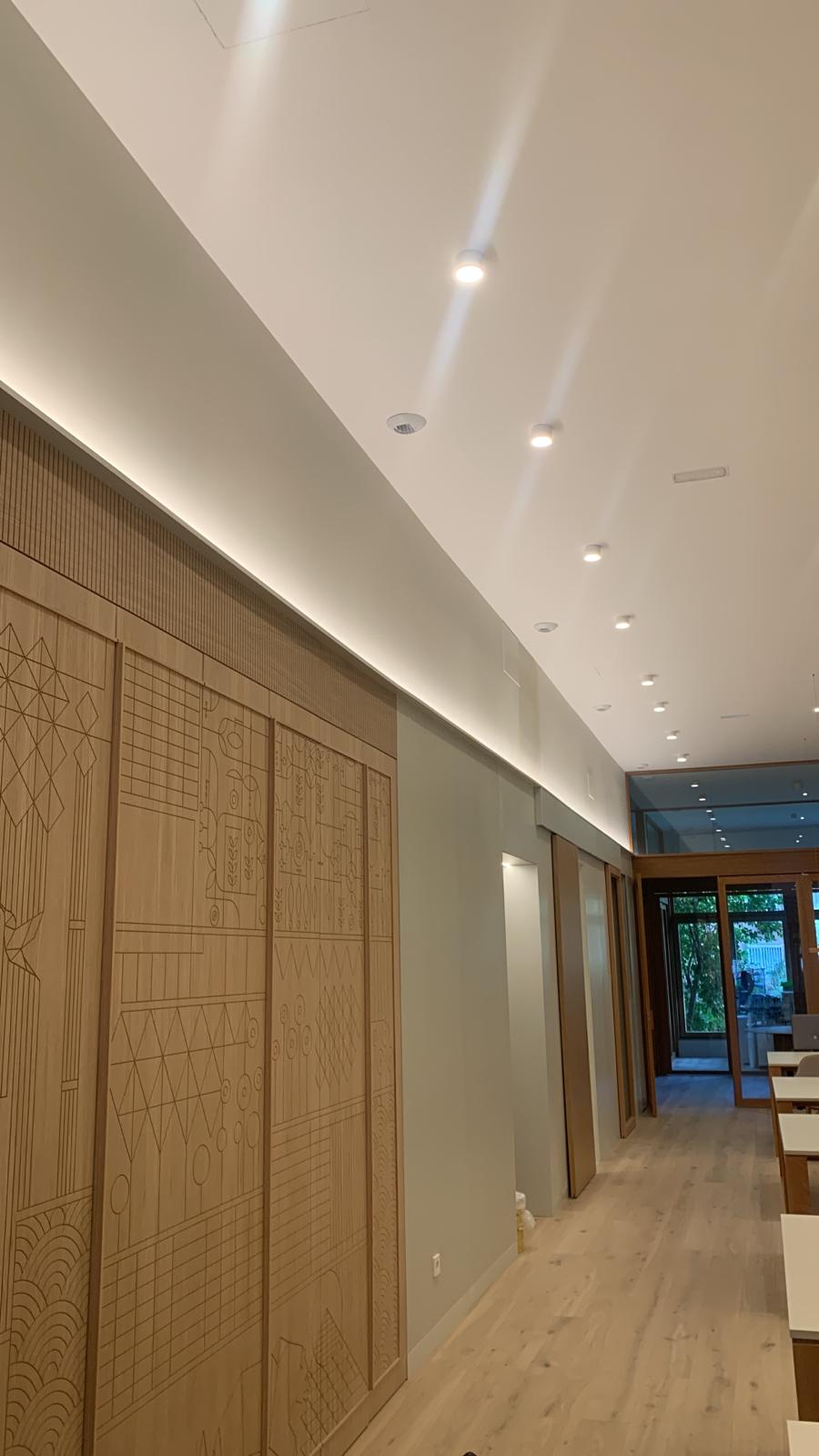 Pasillo con paneles decorativos de madera certificada